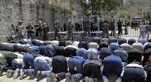 Musulmani pregano fuori dalla moschea di Al Aqsa sotto lo sguardo dei soldati israeliani