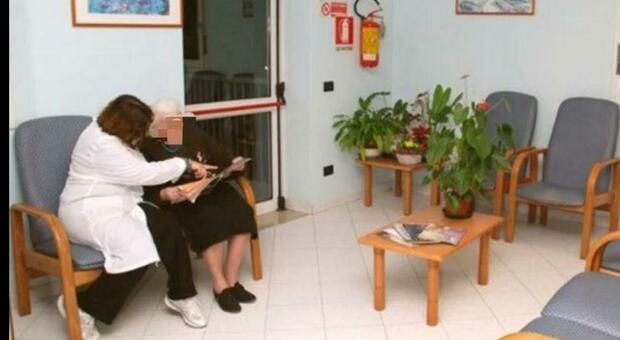Un'infermiera accanto a un'anziana in una casa di riposo