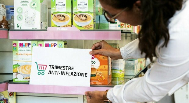 Una farmacista affigge il cartello del "Trimestre anti-inflazione" vicino ad alcuni prodotti