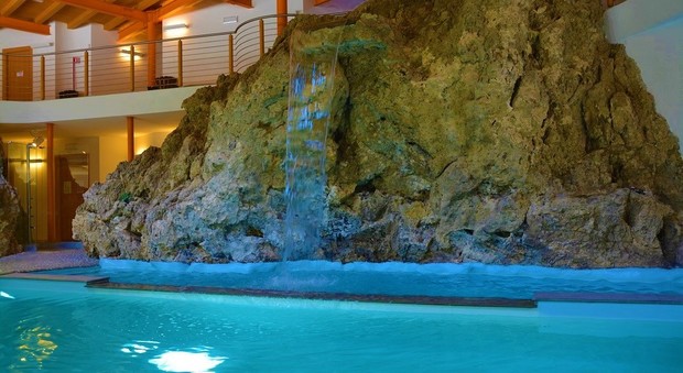 La piscina con la roccia del centro benessere di proprietà del Comune di Sauris