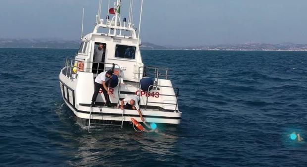 Una motovedetta della Guardia costiera presta soccorso a uno dei naufraghi