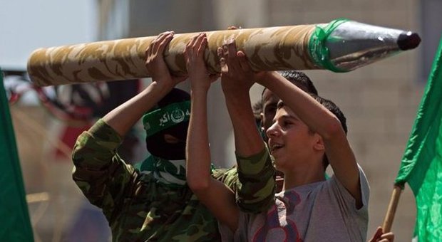 Supporter di hamas con un finto razzo a Ramallah (foto A.Safadi - Epa)