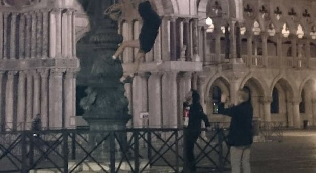 Un turista si arrampica in piazza San Marco, simbolo del degrado in città