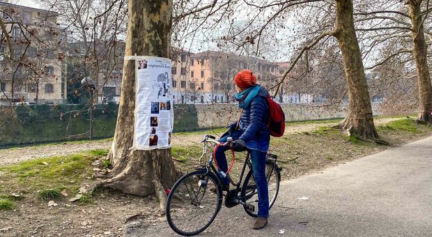 Padova. Un fiocco rosso in cimitero per «Giulia Cecchettin e le donne uccise». Lungo il Piovego c'è chi si ferma a leggere il papiro