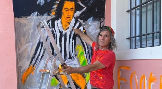 Il pittore Mangone mentre completa il murales