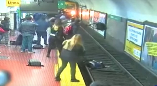 Donna cade sui binari mentre arriva il treno: salva grazie alla folla che blocca il conducente
