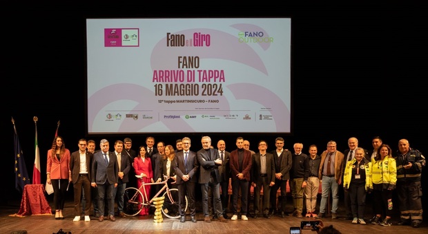 A Fano il 16 maggio arriva il Giro d'Italia, la tappa presentata in teatro: «Il ciclismo è un volano per il turismo». Nella foto grande foto di gruppo sul palco