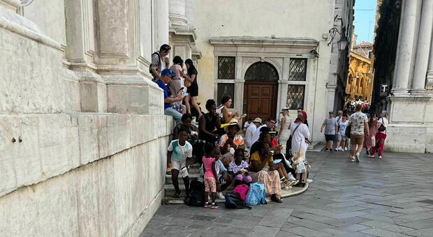 SCENE ORDINARIE Turisti che sostano e mangiano sui gradini delle chiese come anche nei campi e nelle calli