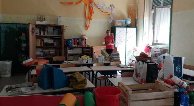 Una maestra pulisce l'aula alla vigilia del primo giorno di scuola