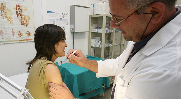 Un pediatra vaccina un adolescente