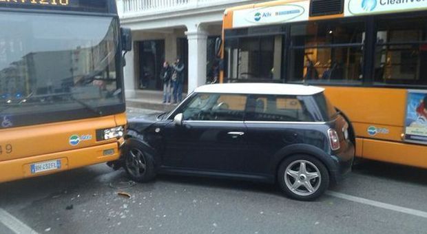 Sorpasso azzardato, la sua Mini s'incastra fra i bus: traffico nel caos