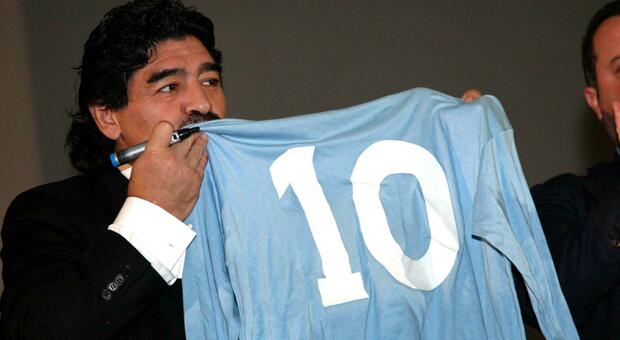 Maradona bacia la maglia azzurra con il numero 10 in uno dei suoi ultimi viaggi a Napoli