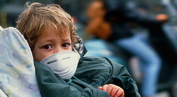 Un bambino con la mascherina anti inquinamento a causa dei livelli di smog troppo elevati