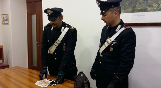 I soldi e la borsa recuperati dai carabinieri