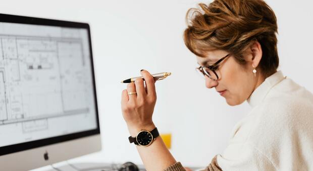 Una donna al lavoro al computer con i suoi occhiali