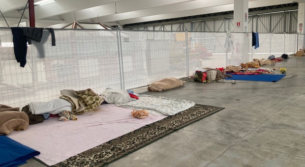 Migranti nell'hangar in Comina, rischio emergenza sanitaria. In 40 con soli 2 bagni e un lavandino. E mancano i letti