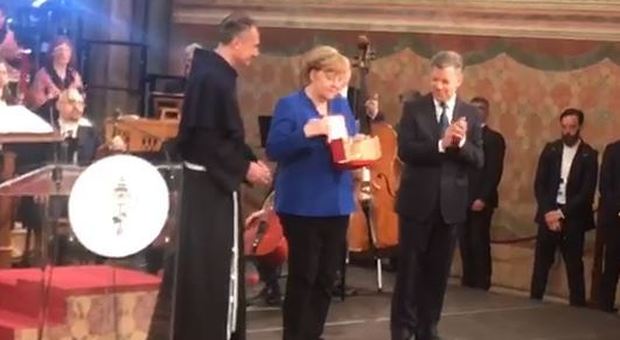 Assisi, la Lampada della Pace alla Merkel: la cancelliera in preghiera sulla tomba di San Francesco