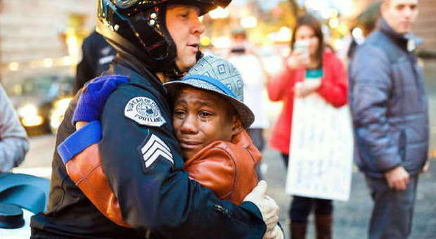 Ferguson, l'abbraccio tra il poliziotto e il ragazzino di colore commuove il mondo: la foto fa il giro del web