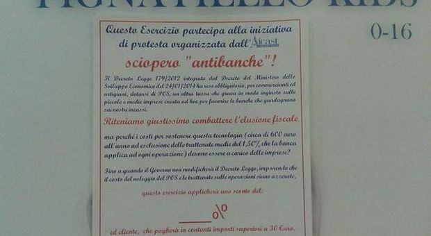 Locandina anti pos affissa sulla vetrina di un negozio a Pomigliano