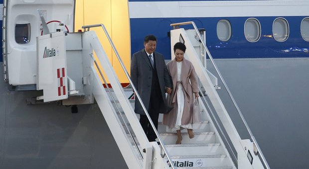 La first lady Peng Liyuan, soprano scesa dall'aereo con un abito bianco sotto un soprabito tortora