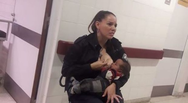 Poliziotta-mamma allatta bimbo malnutrito di una detenuta, la foto diventa virale