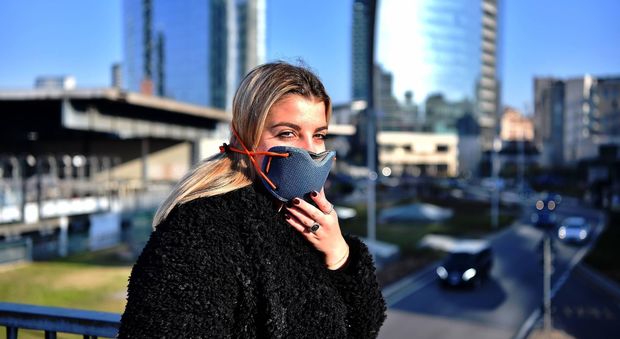 Una ragazza con la mascherina per proteggersi dalle polveri sottili (Fotogramma)