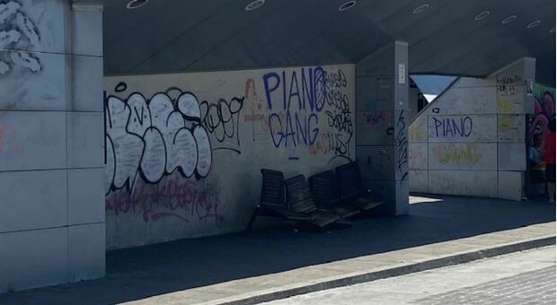 Ancona, piazza Ugo Bassi capolinea dell’inciviltà: la pensilina dei bus assaltata dai teppisti Sui graffiti la firma: «Piano Gang»