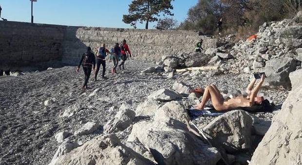 Nudista temeraria a Trieste: prende il sole in spiaggia in mezzo ai runner