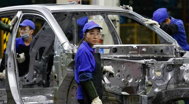Operai al lavoro in una fabbrica di auto in Cina