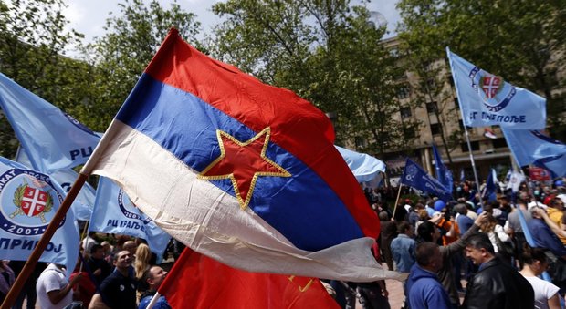 La vecchia bandiera della Serbia sventola durante una manifestazione dei lavoratori a Belgrado