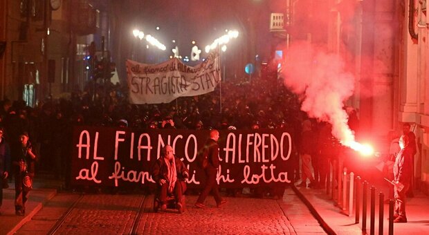 Cospito, centinaia di manifestanti a Torino: lancio di petardi e vetrine rotte