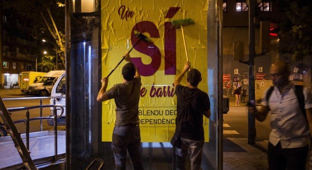 Attivisti catalani espongono un manifesto a favore del voto di domenica
