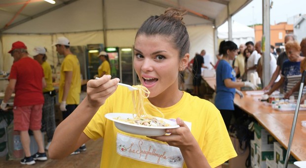 Una giovane ritratta mentre gusta gli spaghetti con le vongole lupino