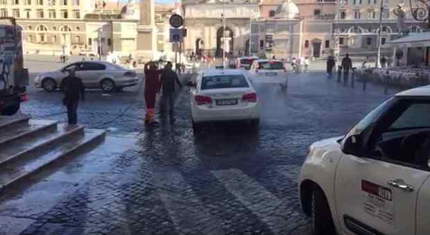 Roma, piazza del Popolo diventa un autolavaggio: l'operatore dell'Ama lava un taxi