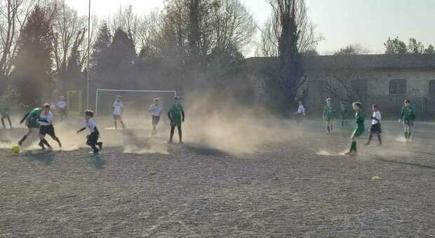 Ragazzini costretti a giocare a calcio in mezzo alla polvere come nel deserto