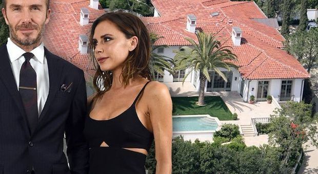 David e Victoria Beckham e, sullo sfondo, la loro villa