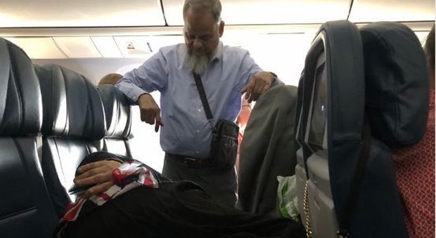 Il marito resta in piedi durante un volo di 6 ore per far riposare la moglie, la foto scatena il web