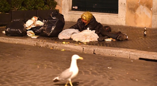 Roma sommersa dai rifiuti: il gabbiano e la clochard si contendono gli scarti