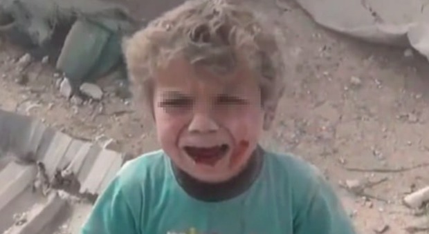 Siria, bimbo ferito cerca la madre fra le macerie della casa bombardata: la sua immagine diventa un simbolo