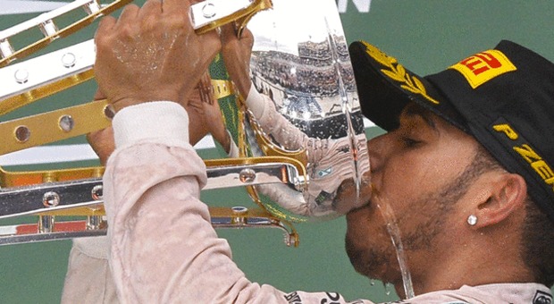 Lewis Hamilton brinda dalla coppa
