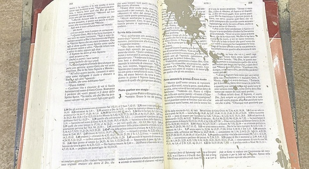 Come un segno: la Bibbia aperta galleggia sul leggio nell'oratorio devastato dall'alluvione