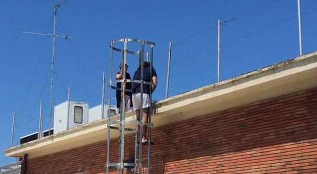 Una donna si arrampica sul tetto per chiedere un posto di lavoro