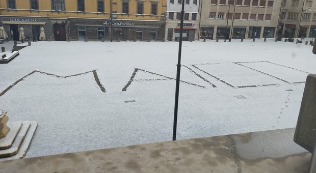 La neve ricopre la città e in piazza appare una scritta: "Maico"