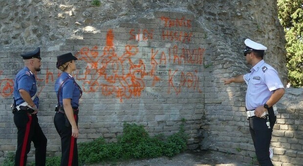 Carabinieri e polizia municipale davanti alle scritte sulle mura romane