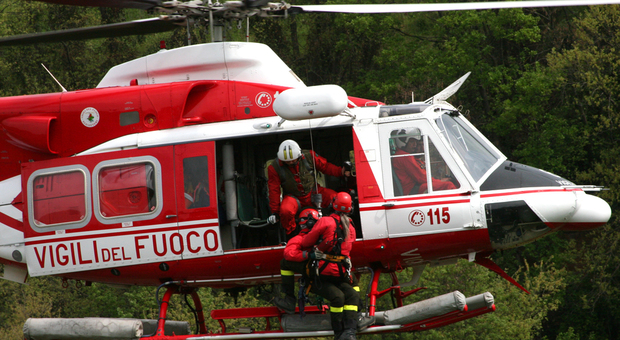 L'elicottero dei vigili del fuoco in volo sopra a un bosco