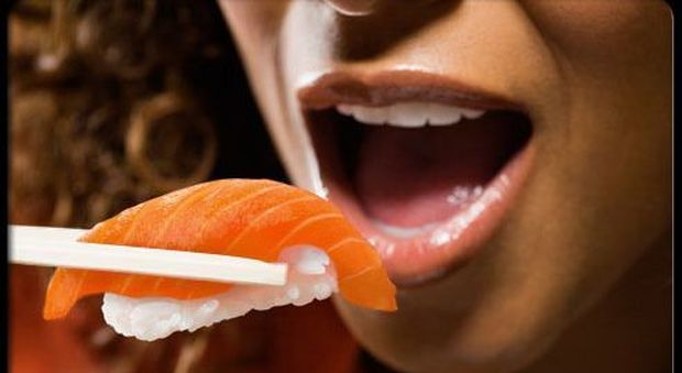 Un ragazza mangia salmone