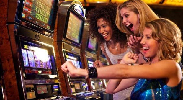 Tre ragazze alle prese con una slot machine