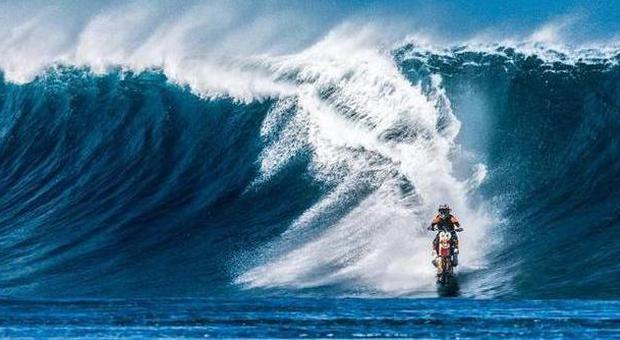 Il pilota cavalca l'onda gigante con la moto: la foto spettacolare fa il giro del web