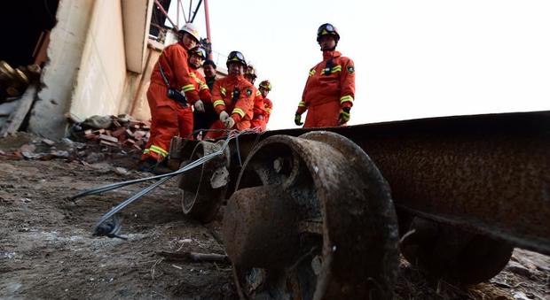 Soccorritori cinesi impegnati nelle operazioni di salvataggio dei lavoratori ancora intrappolati nella miniera di gesso crollata