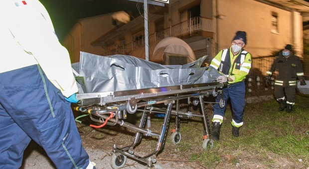 Gli operatori del Suem portano via il cadavere dell'uomo trovato dentro l'abitazione andata a fuco